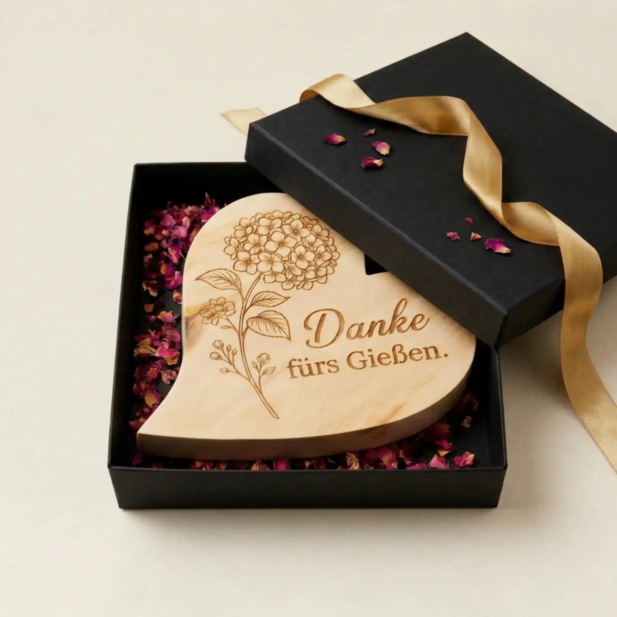 Graviertes Zirbenholzherz "Danke fuers Gießen" in einer edlen schwarzen Geschenkbox mit Rosenblueten. Graviertes Zirbenholzherz "Danke fuers Gießen" in einer edlen schwarzen Geschenkbox mit Rosenblueten.
