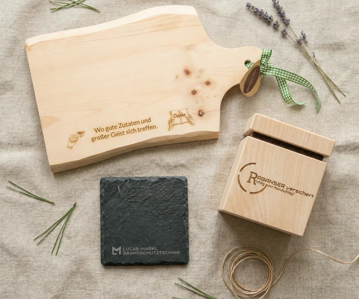 Praezise Logogravur und Symbole auf edlem Pinus cembra und Schiefer - Individuelle Firmengeschenke und Mitarbeitergeschenke aus unserer Werkstatt in Kitzbuehel.