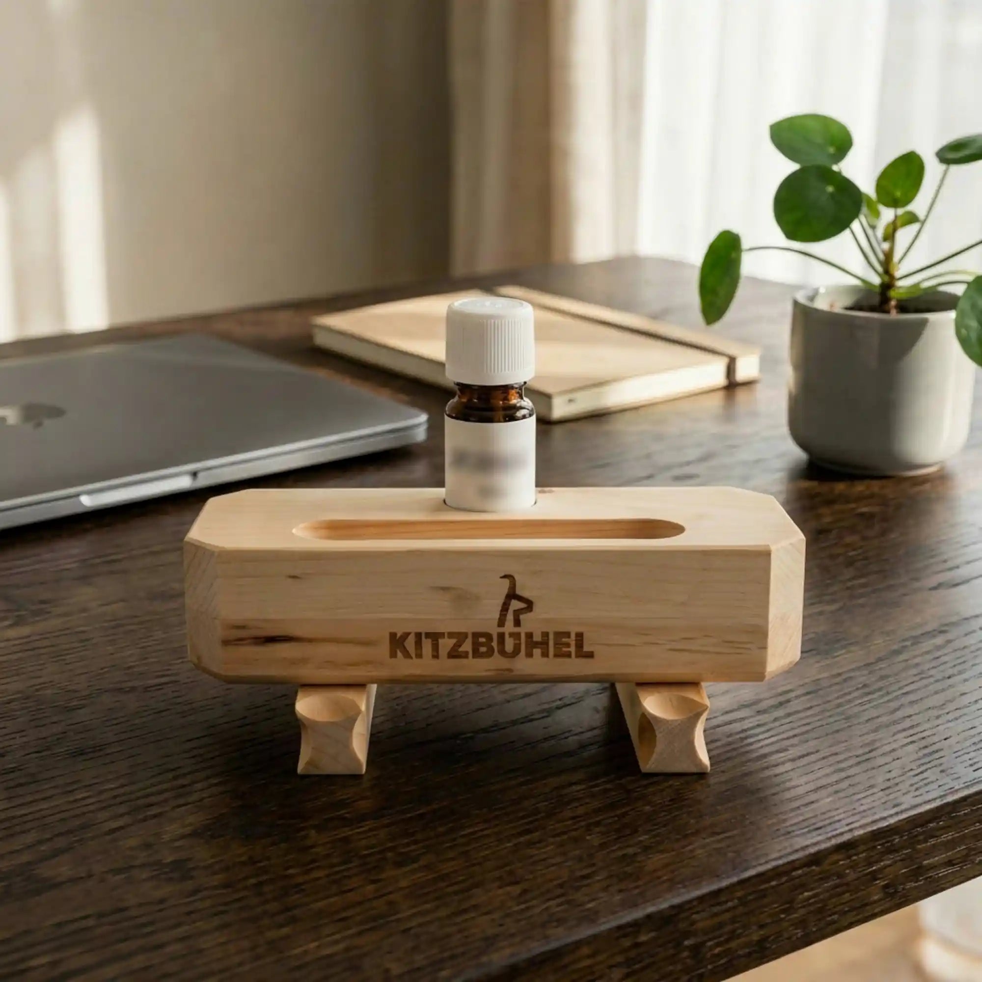Zirbenduft‑Brunnen Kitz‑Edition mit Zirbenoel auf einem Schreibtisch neben Laptop und Pflanzen. Zirbenduft‑Brunnen Kitz‑Edition mit Zirbenoel auf einem Schreibtisch neben Laptop und Pflanzen.