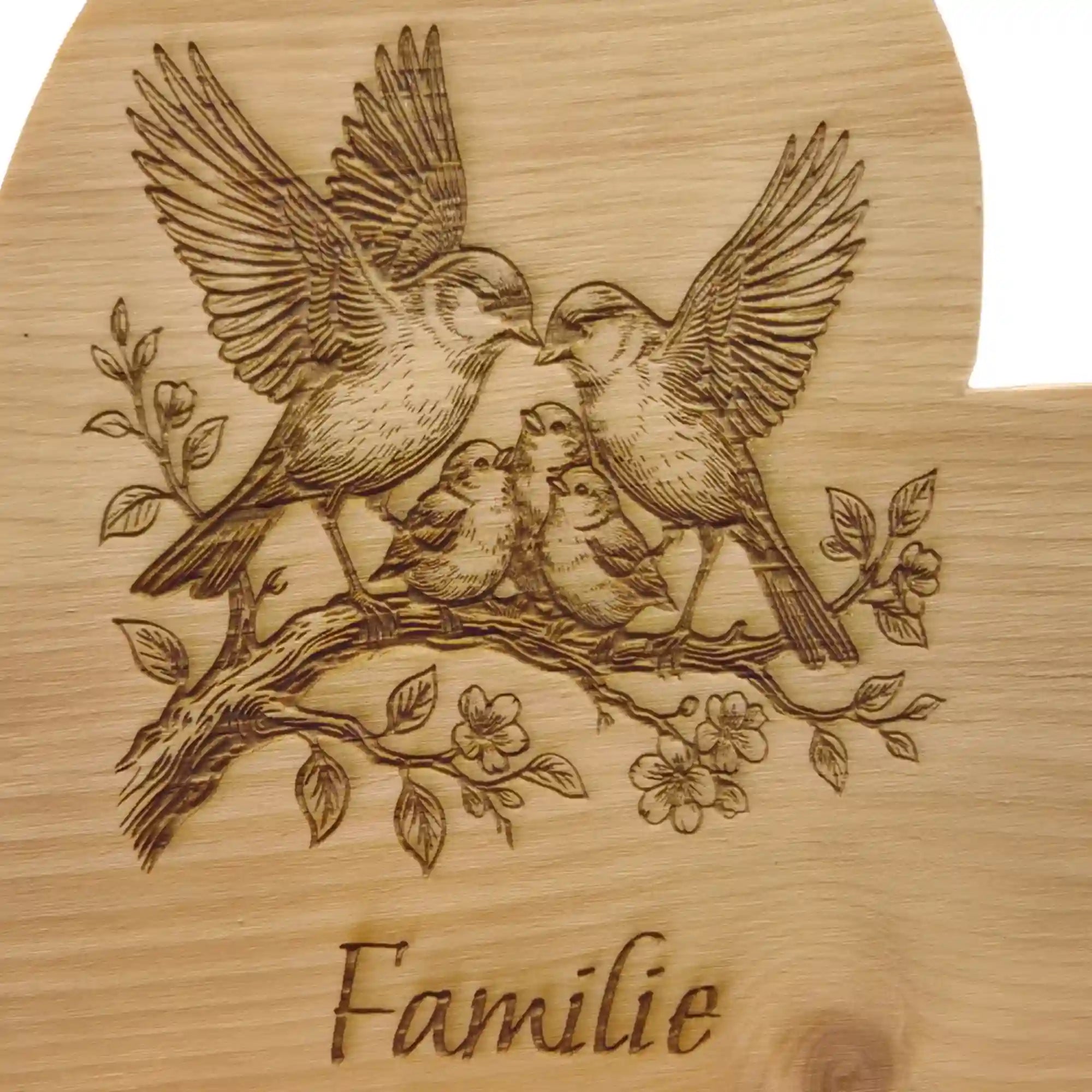 Detailaufnahme der Familie Gravur mit Vogel Familie auf Zirbenherz aus Holz mit sichtbarer Maserung.