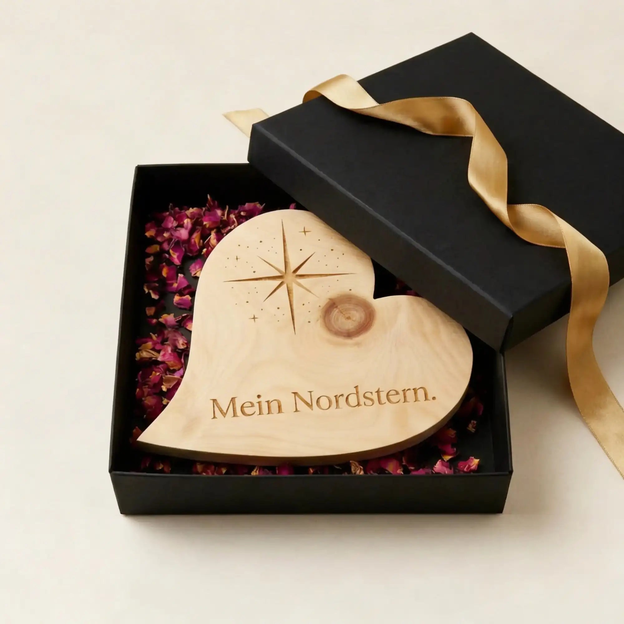 Zirbenholzherz mit Nordstern-Gravur und Schriftzug „Mein Nordstern“ in schwarzer Geschenkbox mit Rosenblueten als Dankeschoen zum Muttertag. Zirbenholzherz mit Nordstern-Gravur und Schriftzug „Mein Nordstern“ in schwarzer Geschenkbox mit Rosenblueten als Dankeschoen zum Muttertag.