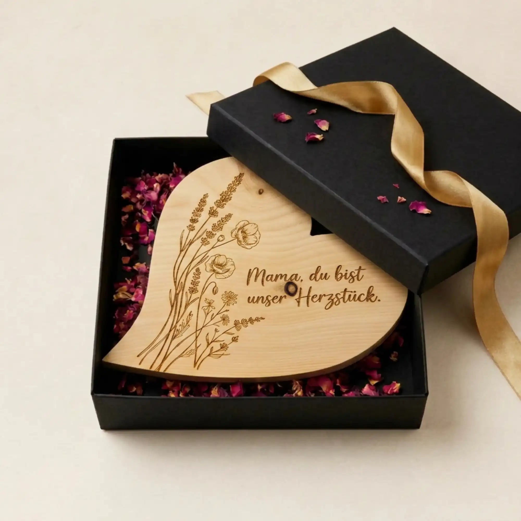 Geoeffnete schwarze Geschenkbox zum Muttertag 2026 mit Zirbenherz Mama. du bist unser Herzstueck auf duftenden Rosenblueten. Geoeffnete schwarze Geschenkbox zum Muttertag 2026 mit Zirbenherz Mama. du bist unser Herzstueck auf duftenden Rosenblueten.