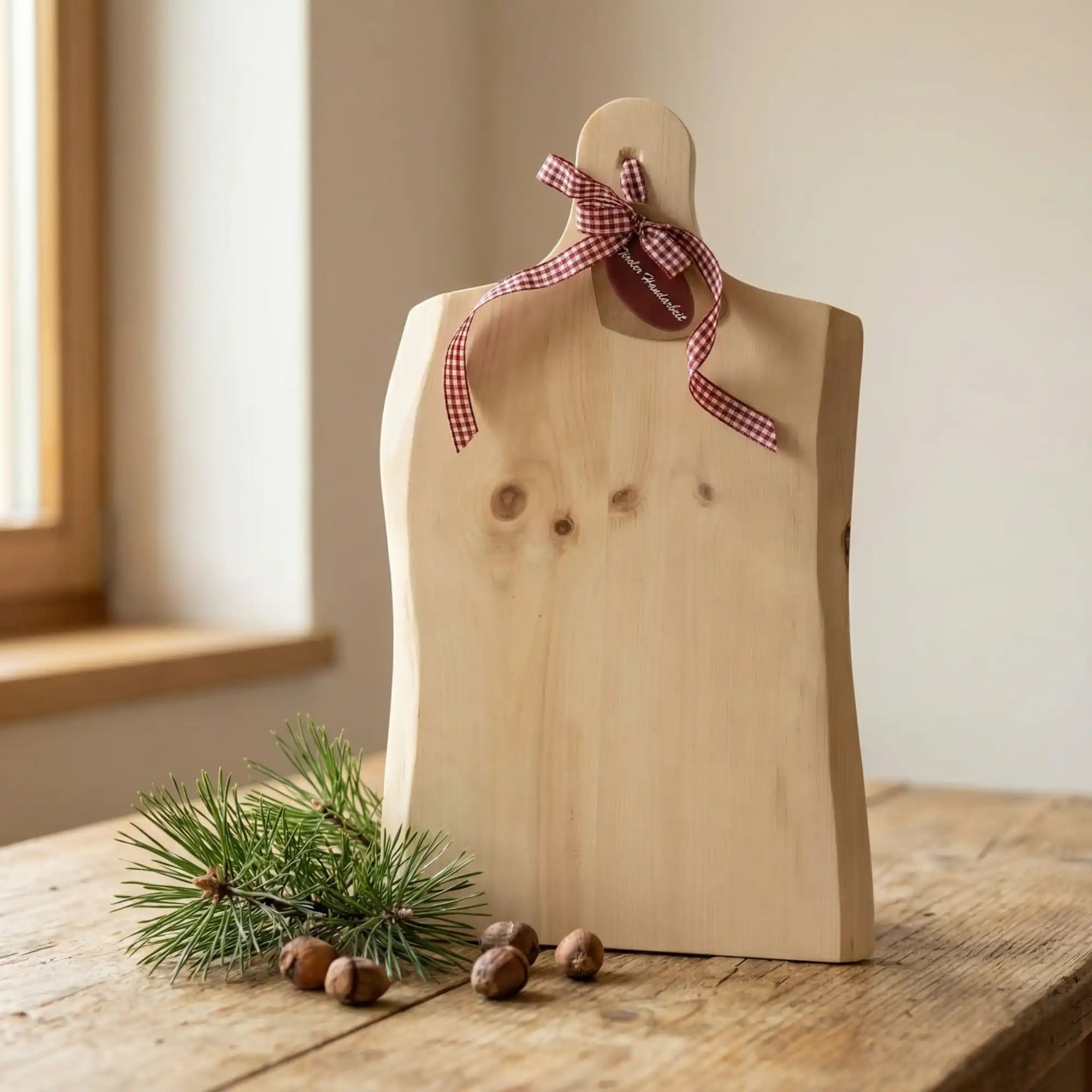 Personalisiertes Zirbenholz Jausenbrett mit Foto Gravur und roter Schleife am Griff als liebevolle Dekoration aus Kitzbuehel. Personalisiertes Zirbenholz Jausenbrett mit Foto Gravur und roter Schleife am Griff als liebevolle Dekoration aus Kitzbuehel.