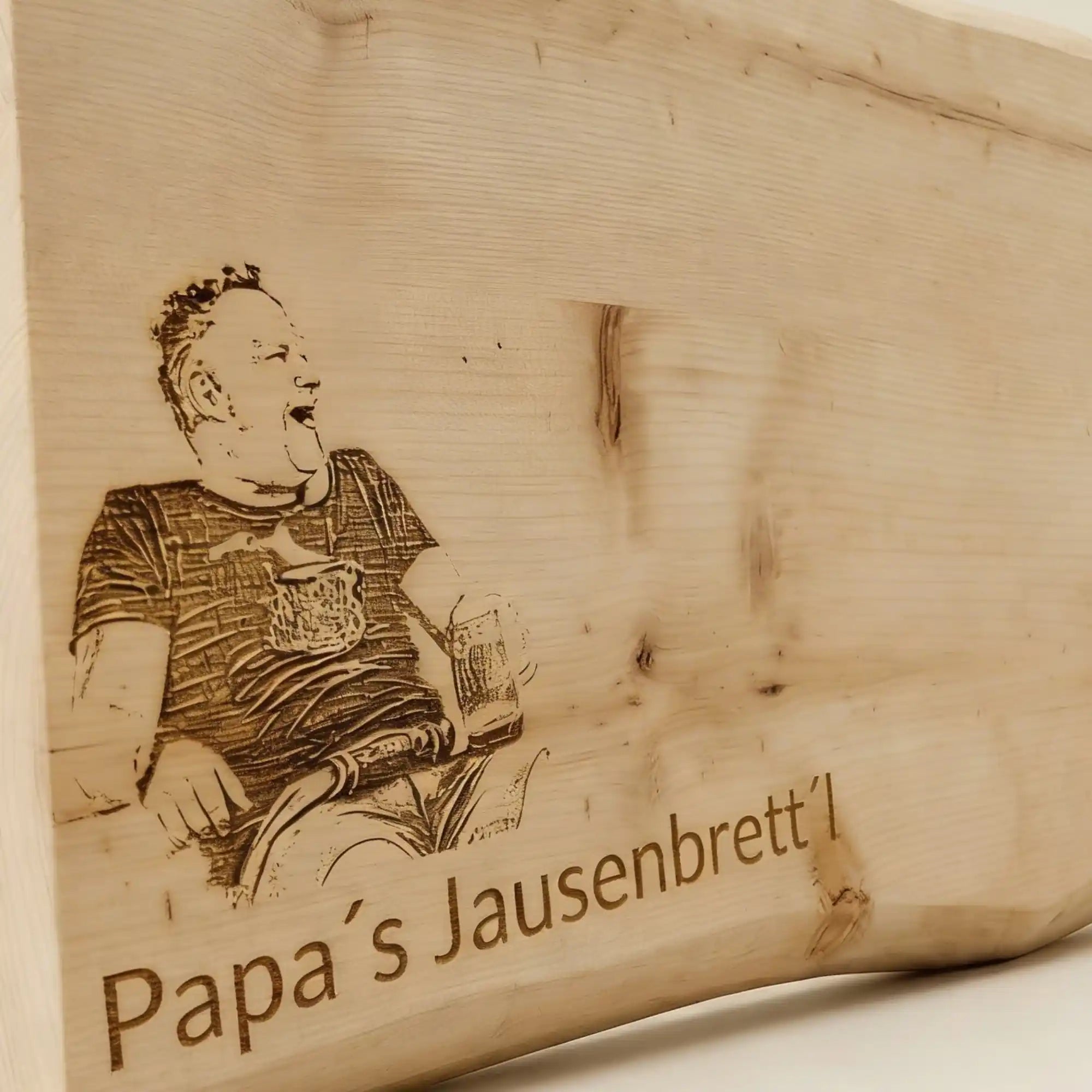 Nahaufnahme der Fotogravur auf Zirbenholz mit Schriftzug Papas Jausenbrettl. Detail der praezisen Lasergravur als Geschenkidee fuer Maenner. Nahaufnahme der Fotogravur auf Zirbenholz mit Schriftzug Papas Jausenbrettl. Detail der praezisen Lasergravur als Geschenkidee fuer Maenner.