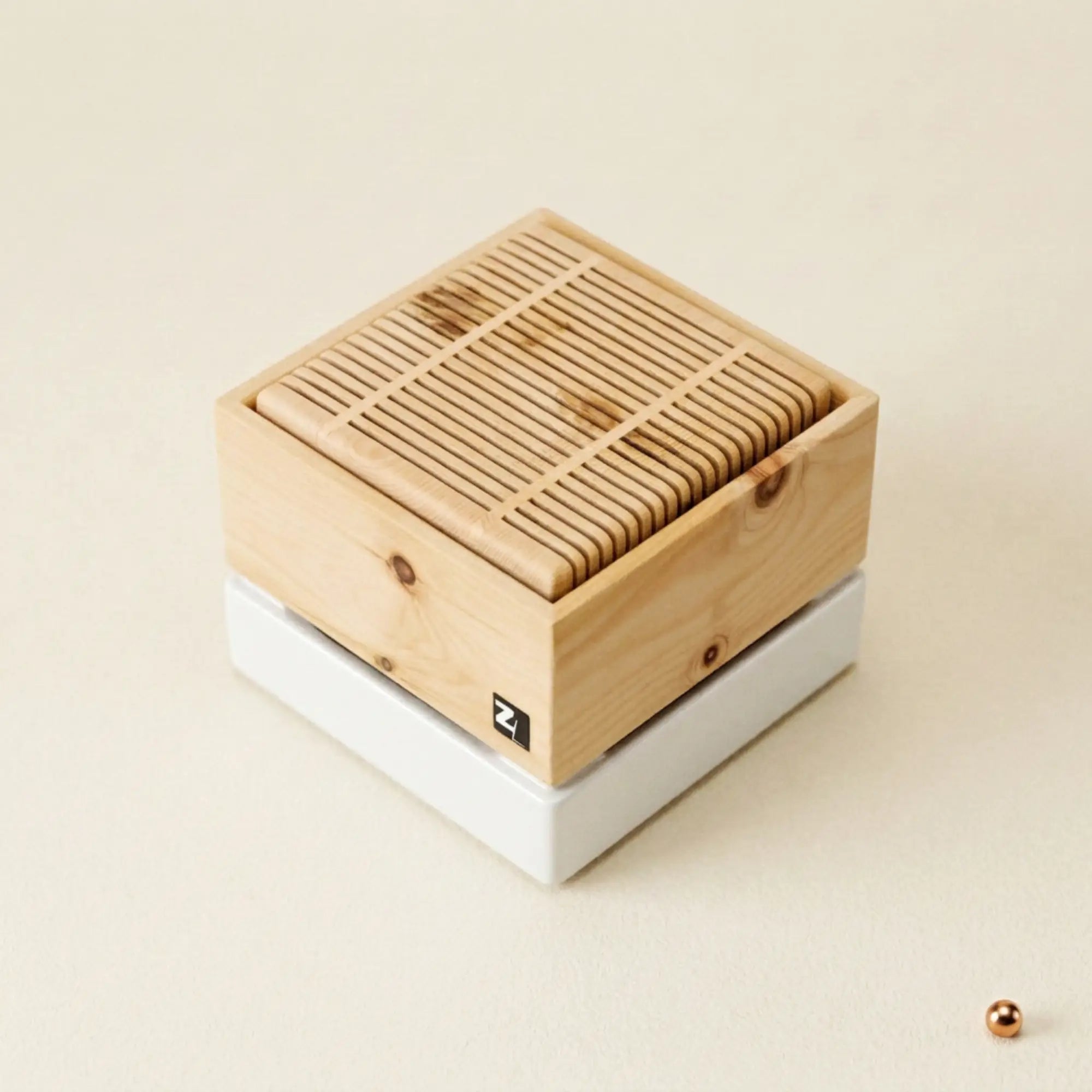 ZirbenLuefter Cube II mini aus Zirbenholz und Gmundner Keramik auf Hintergrund mit Kupferpunkt.