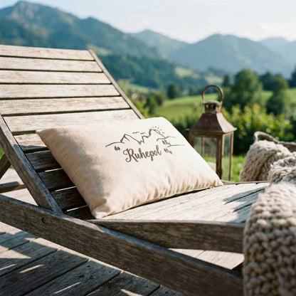 Zirbenkissen Zirbenprodukt 30x20 cm mit natürlichen Zirbenflocken und der Aufschrift Ruhepol mit minimalistischer grafik bestehnd aus berg sonne tannenbäumen und wandereren auf der liegestuhl aus holz, grüne wiesen und bergpanorama im hintergrund