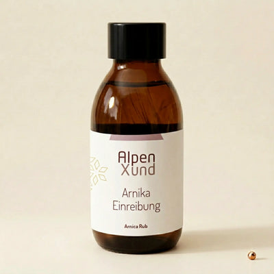 Arnika Einreibung in der Braunglasflasche auf einem minimalistischen beigen Hintergrund mit einem dezenten metallischen Kupferpunkt.