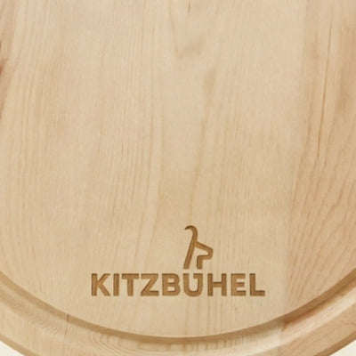 Rundes Zirbenholz‑Jausenbrett der Kitz‑Edition mit lizenzierter Kitzbuehel‑Gravur in Nahaufnahme, gefertigt aus massiver Tiroler Zirbe.