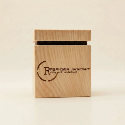 Zirbenwuerfel mit Firmenlogo Gravur fuer Versicherungen als nachhaltiges Werbegeschenk durch Lasergravur auf Zirbenholz.