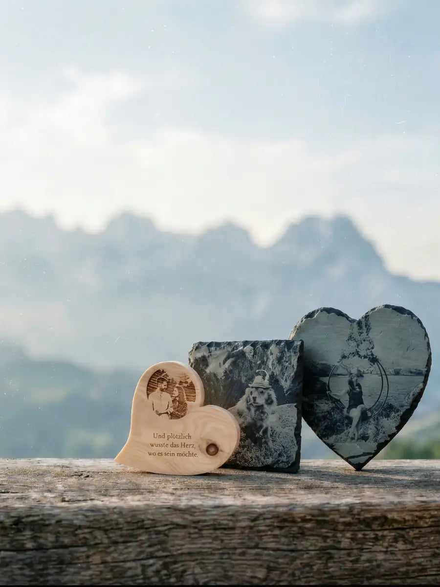 Personalisiertes Zirbenherz und Schieferherz mit Fotogravur von Menschen und Hund vor dem Bergmassiv Wilder Kaiser.