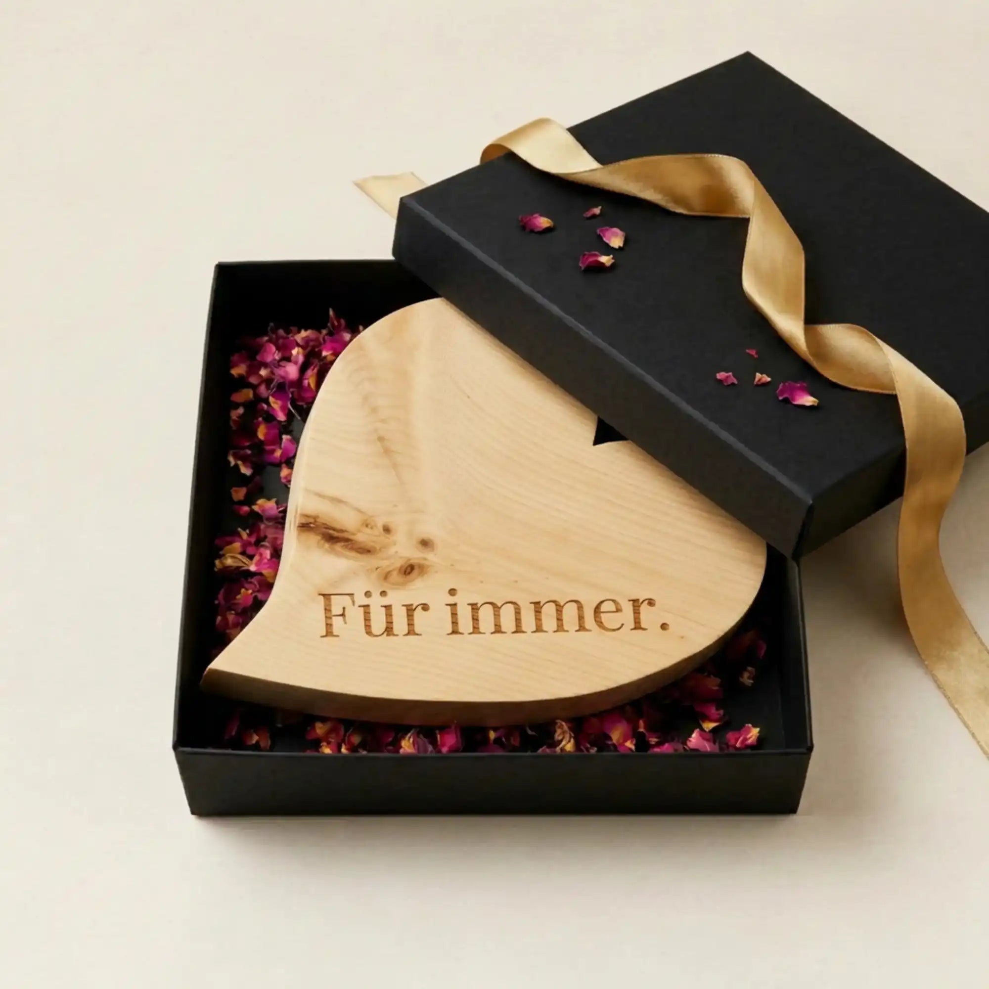 Stilvolle Präsentation des „Für immer“ Zirbenherzens in einer edlen schwarzen Box mit Goldschleife – bereit zum Verschenken.