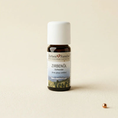 Naturbelassenes aetherisches Zirbenoel 10ml in dunkler Glasflasche auf strukturiertem Buettenpapier, von GeschenkeReich Kitzbuehel.