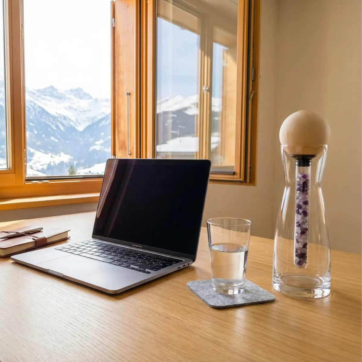 Glaskaraffe Set mit Zirbenkugel Tiroler Adler und Edelsteinstab auf aufgeräumtem Schreibtisch vor dem Wilden Kaiser in Kitzbühel.