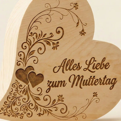 Detailansicht der tiefen Gravur „Alles Liebe zum Muttertag“ mit Herzverzierung auf einem massiven Zirbenherz.