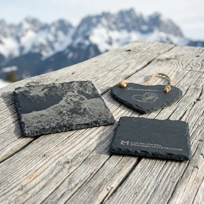 Edle Schieferplatten mit Gravur auf massivem Zirbenholz vor dem Wilden Kaiser in Ellmau – personalisierte Geschenke aus Tiroler Handwerk.