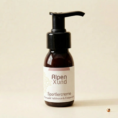 Aufrecht stehende Sportlercreme Braunglasflasche auf beigem Hintergrund von Bild 2 mit kleinem Kupferpunkt rechts unten.