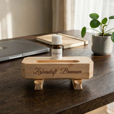 Zirbenduft-Brunnen auf einem modernen Schreibtisch neben einem Laptop.