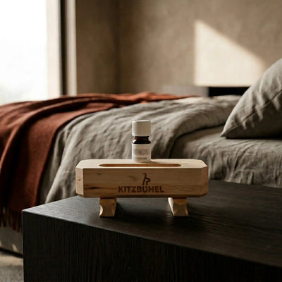 Zirbenduft‑Brunnen Kitz‑Edition mit 10 ml Zirbenoel auf einem modernen Nachttisch in einem stilvollen Schlafzimmer.