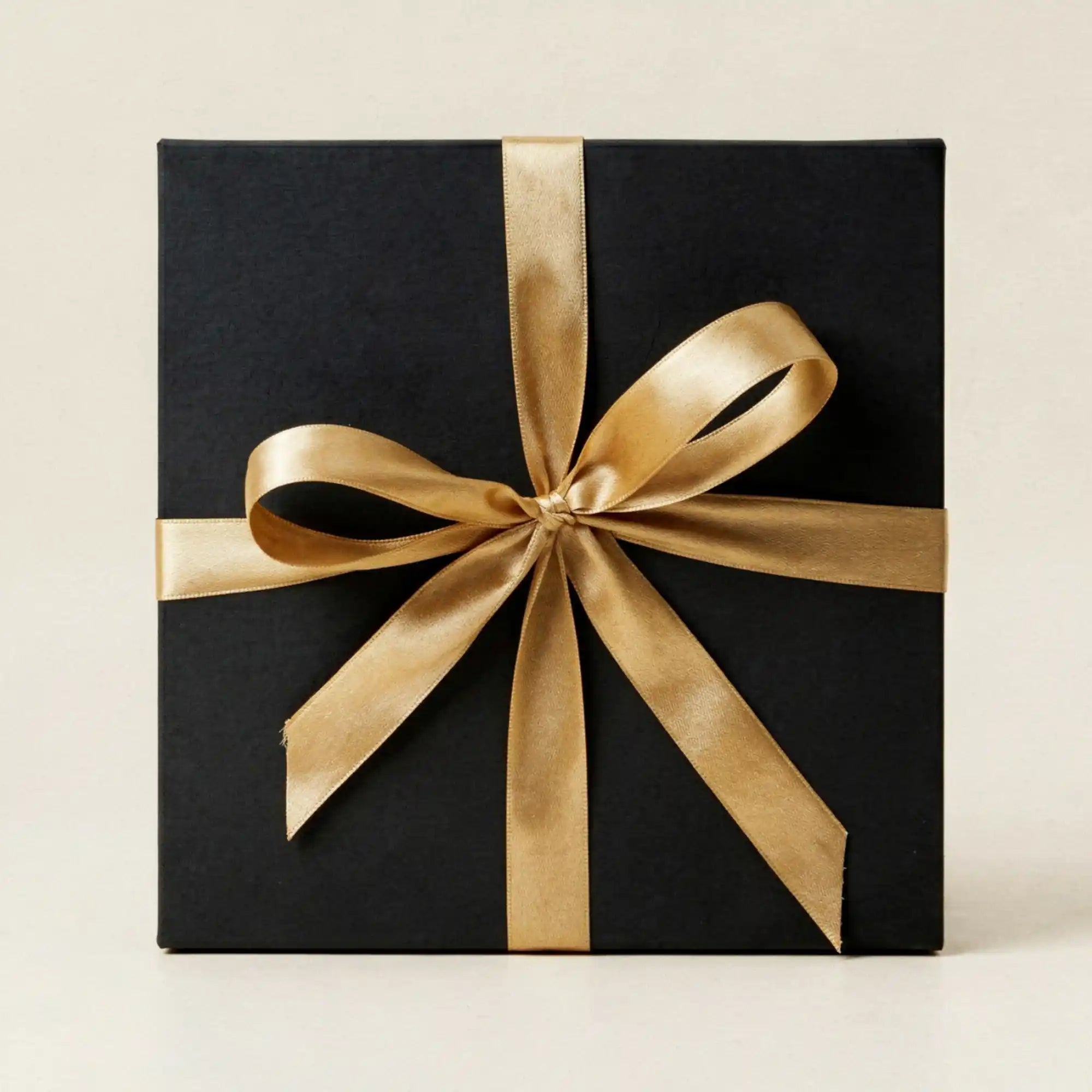 Edle schwarze Geschenkebox mit eleganter goldener Satinschleife als fertige Verpackung fuer das Zirbenherz zum Muttertag.