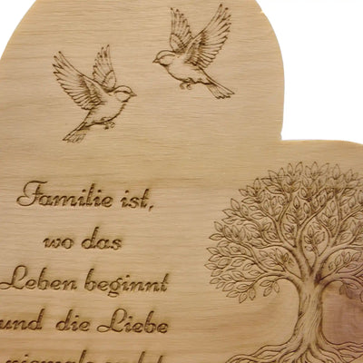 Detailaufnahme der Lasergravur mit Voegeln und Lebensbaum auf massivem Zirbenherz mit Familien-Spruch aus Zirbenholz.