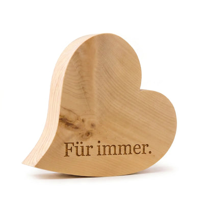 Herzfoermiger Aufsteller aus massivem Alpen‑Zirbenholz mit Gravur „Fuer immer“ freigestellt auf weissem Hintergrund.