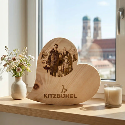 Zirbenholz Herz mit Foto Gravur einer Familie und Kitzbuehel Logo vor Muenchen Skyline. Romantische Deko Idee.