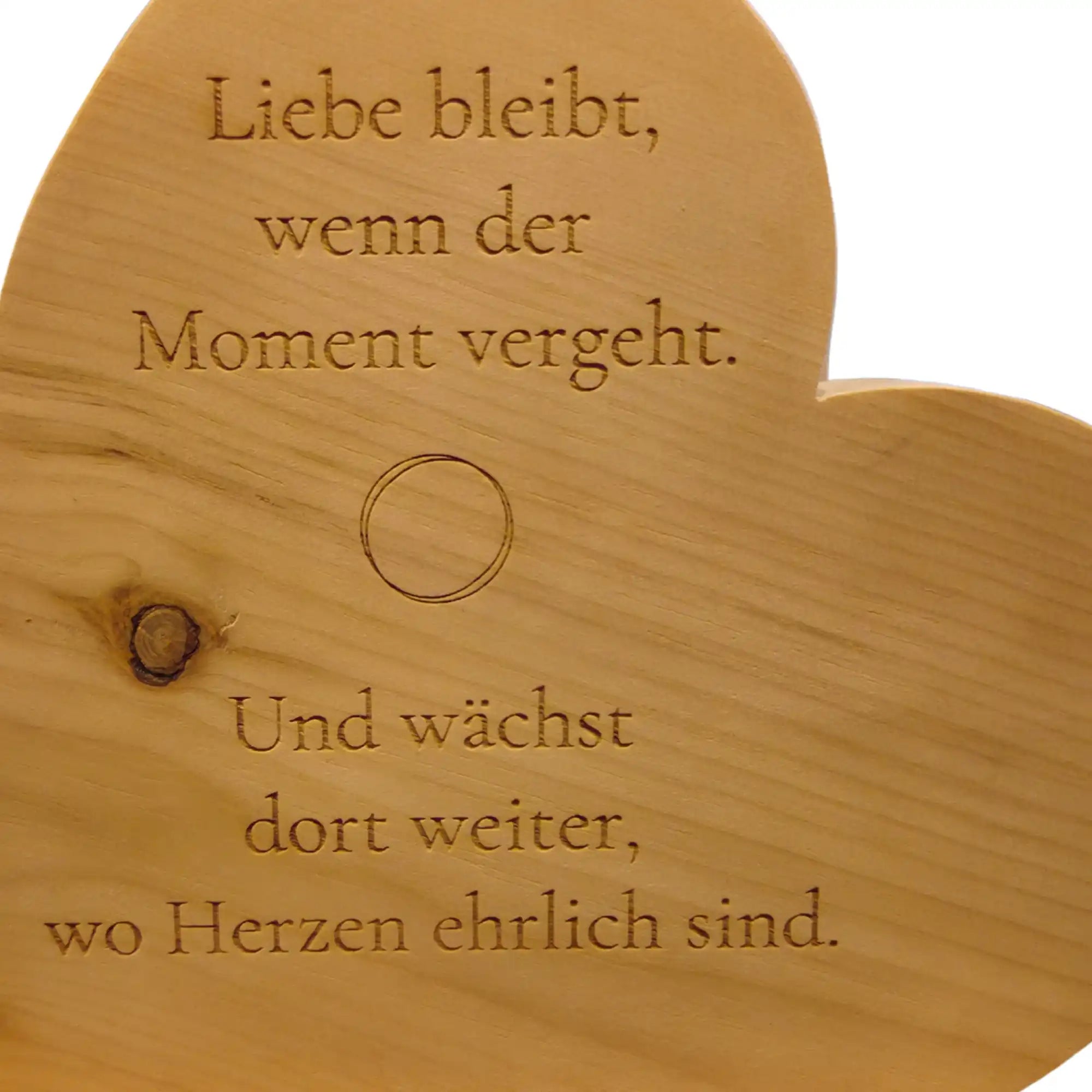 Detailaufnahme der Liebe Gravur auf Zirbenherz aus Holz als Geschenk fuer Paare mit sichtbarer Holzstruktur.