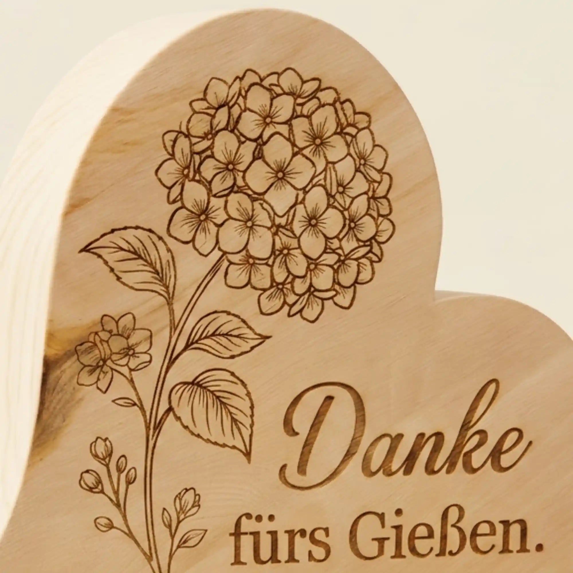 Zirbenherz Muttertagsgeschenk Detailansicht der präzisen Hortensien-Lasergravur mit dem Schriftzug ‚Danke fürs Gießen‘ auf duftendem Zirbenholz.