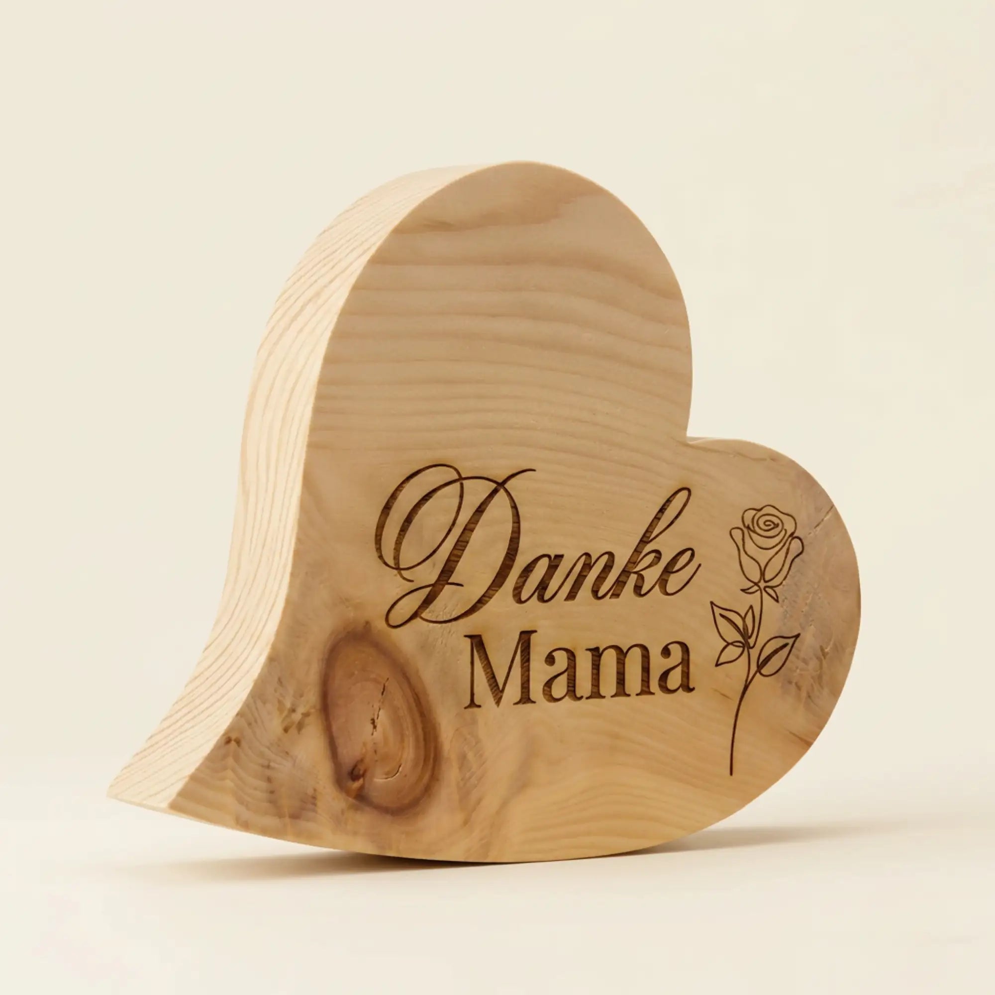 Zirbenherz Muttertagsgeschenk 'Danke Mama' mit Rosen-Gravur aus massivem Zirbenholz als stehender Aufsteller auf hellem Hintergrund.