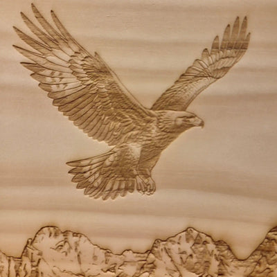 Detailaufnahme der Steinadler‑Lasergravur auf massivem Zirbenholz mit Bergmotiv Wilder Kaiser von GeschenkeReich Kitzbuehel.