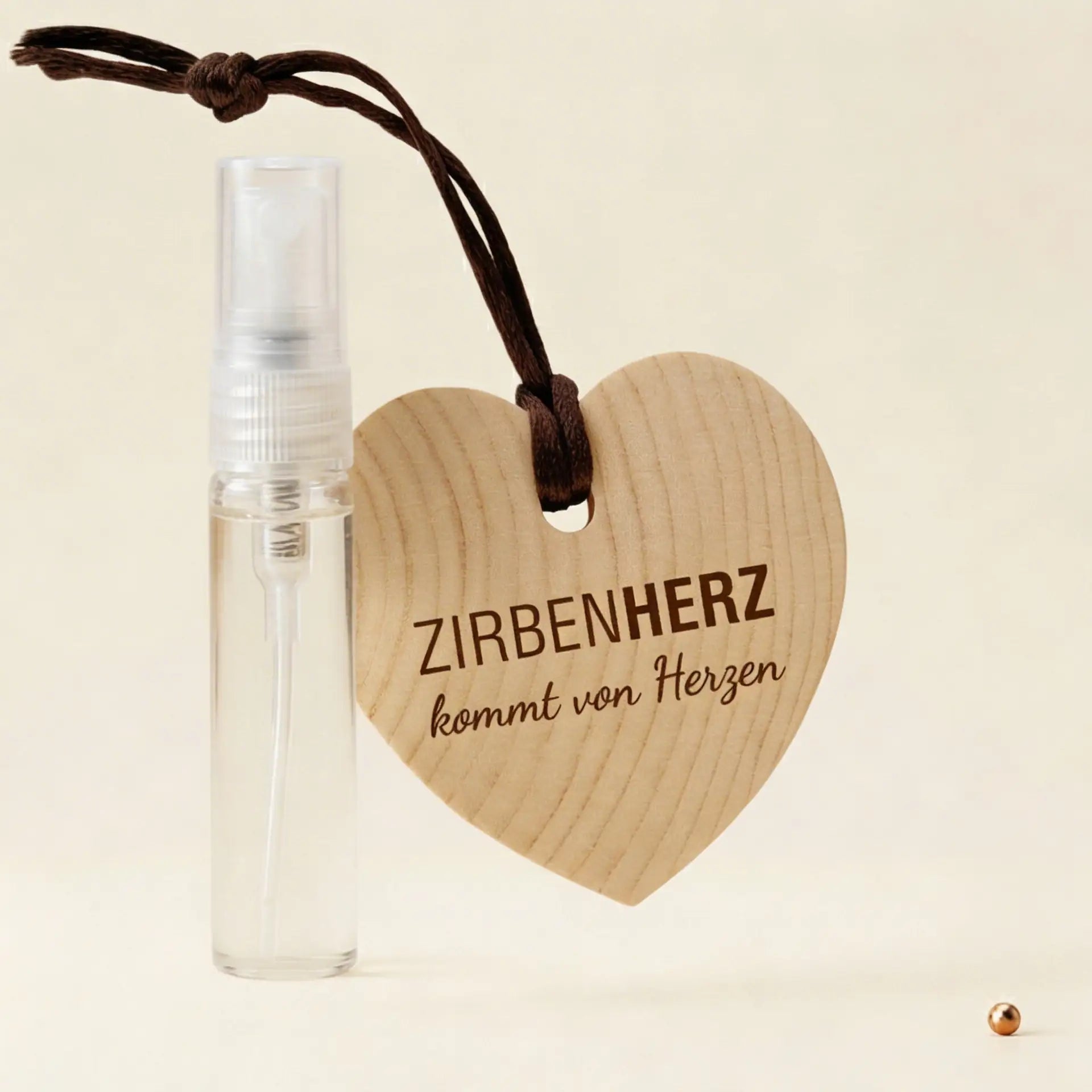 ZirbenHerz Geschenkset mit 5ml ZirbenSpray auf dekorativem Hintergrund mit Kupferpunkt-Elementen.