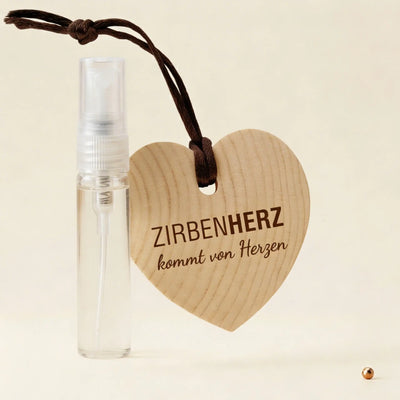 ZirbenHerz Geschenkset mit 5ml ZirbenSpray auf dekorativem Hintergrund mit Kupferpunkt-Elementen.