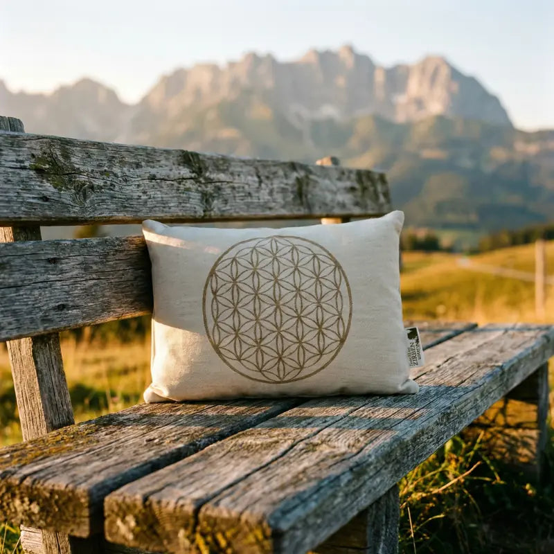 Hochwertiges Zirbenkissen von GeschenkeReich auf einer rustikalen Holzbank vor dem Panorama des Wilden Kaisers in Kitzbuehel bei goldenem Sonnenuntergang