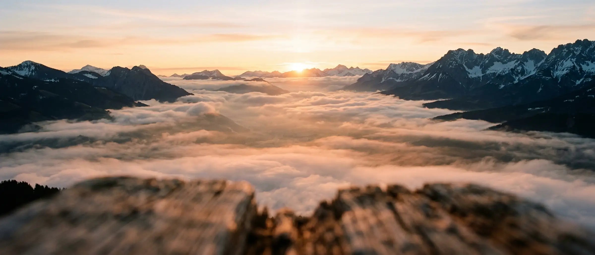 Sonnenaufgang über Kitzbueheler Alpen mit Morgennebel. Heimat unserer handgefertigten Zirbenprodukte von GeschenkeReich.