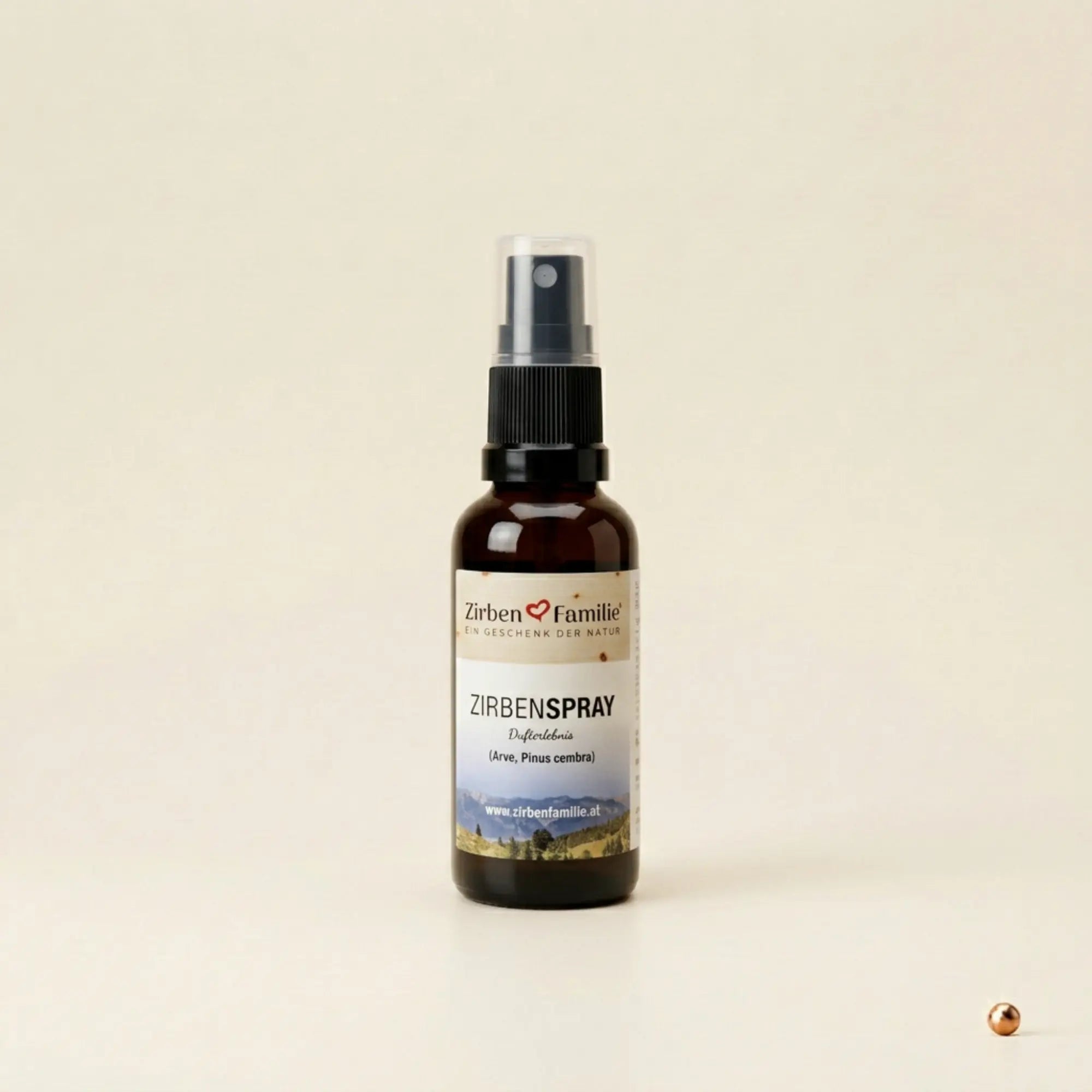 Kleine 20ml Zirbenspray Flasche stehend und zentriert auf hellem strukturiertem Papier mit Kupferpunkt-Akzent.
